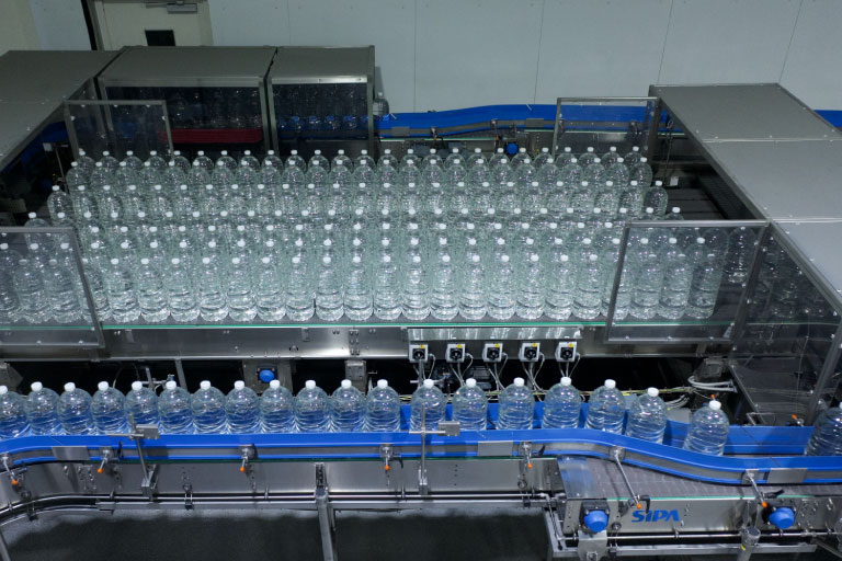 Plastic bottles filled and capped on production line